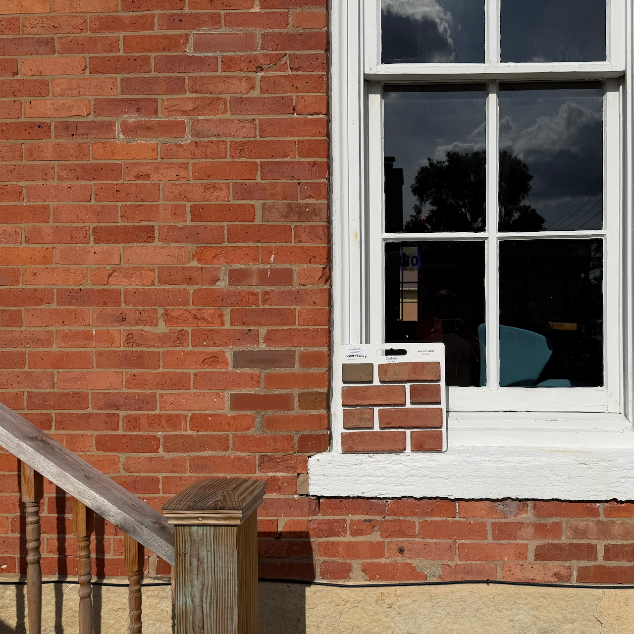 Brick color sample 6 held against the existing brick wall